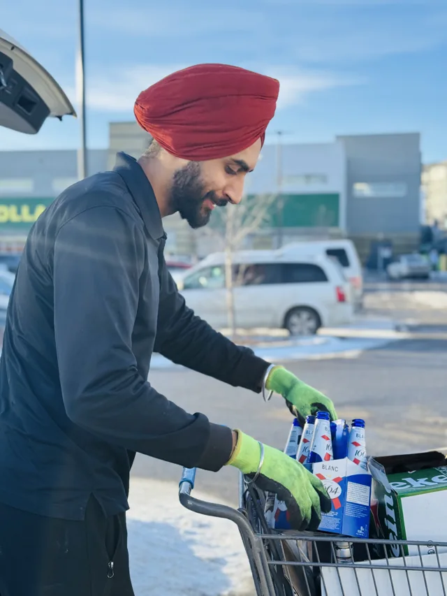 A Sage Hill team member unloading containers beside a customer's vehicle
