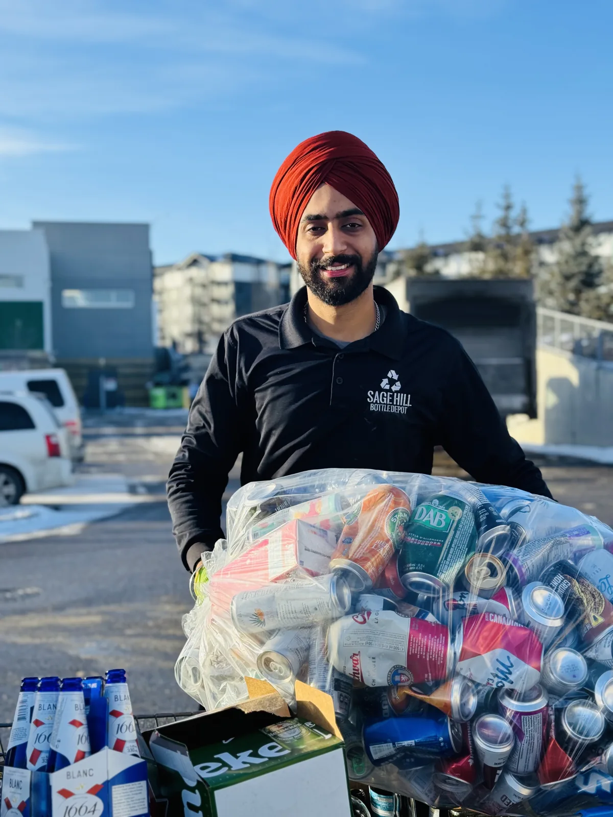 A smiling Sage Hill team member ready to help with bags of bottles